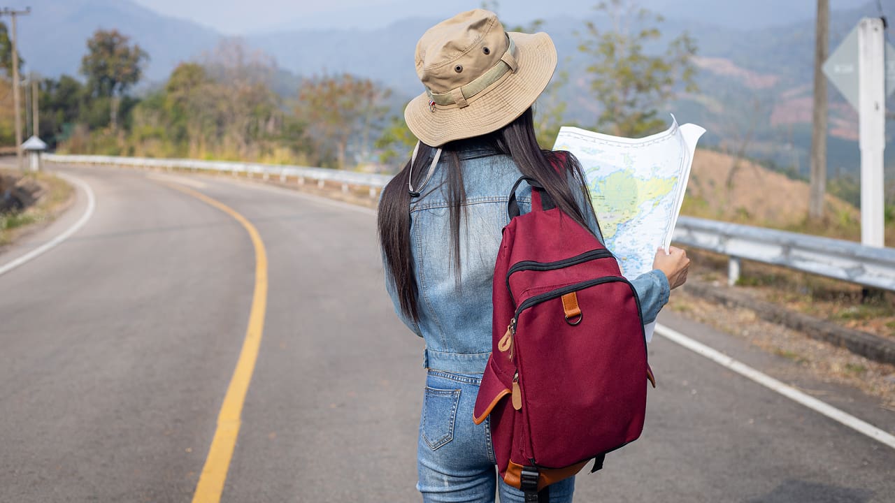 A girl searching right direction on a map while traveling