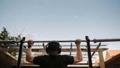 sports man in headset pulling up on bar