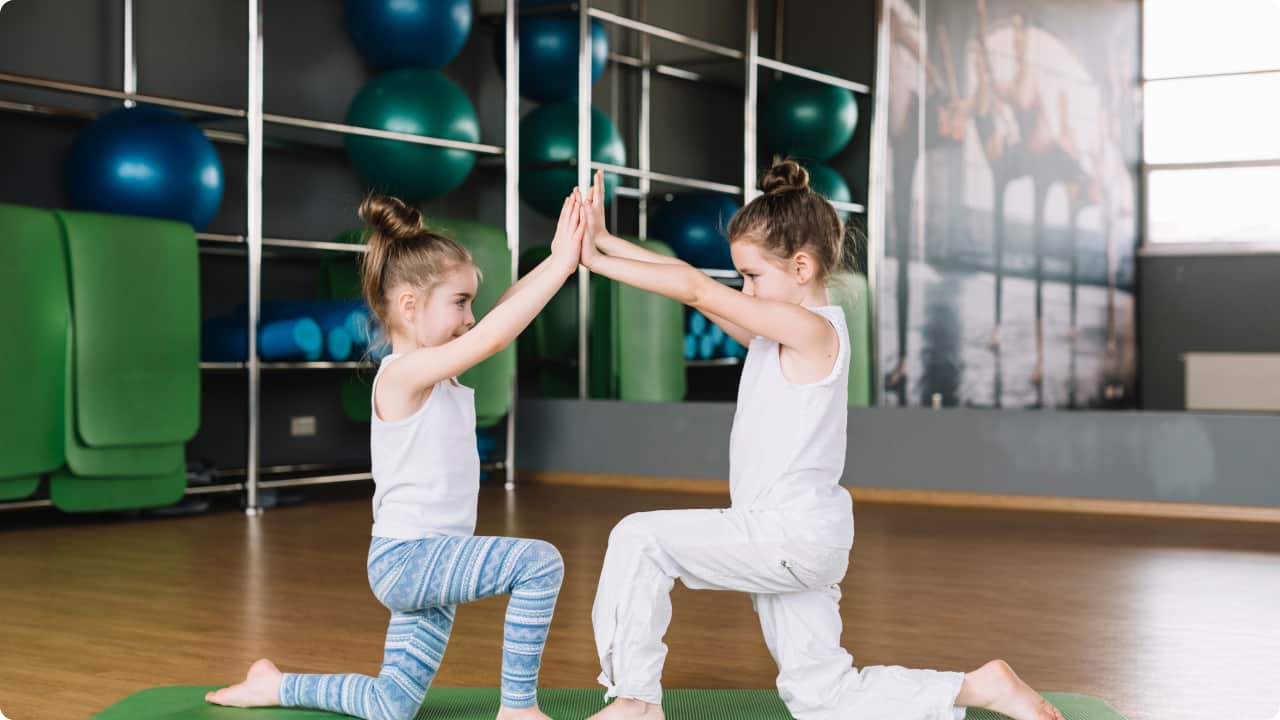 two girls exercising together in a gym