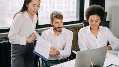 Group Wearing Employee Uniforms in Front of Laptop