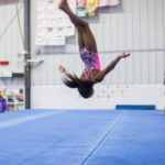 a girl is doing advance tumbling which is a gymnastic technique