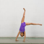 a girl is doing a cartwheel and round-off which is an aerobic skill