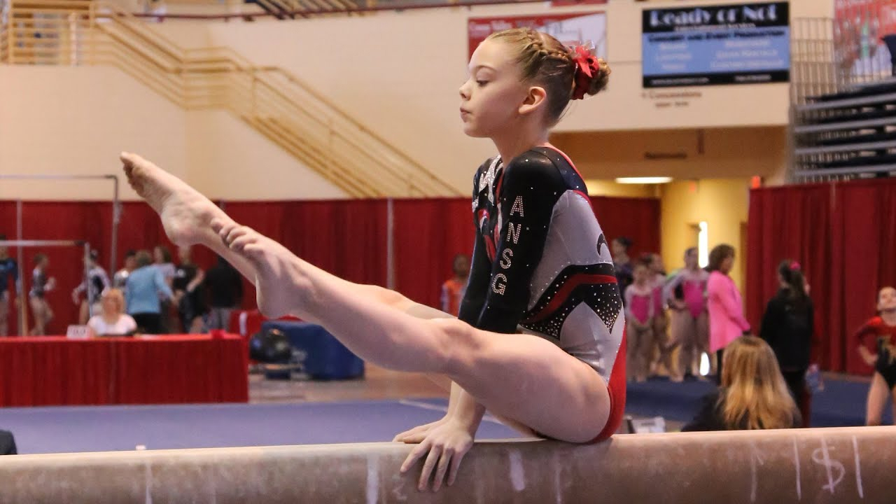 a girl is performing some skills on the uneven bar in level 7