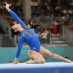 a girl is lying on a floor and doing acrobatics