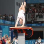 a girl is doing vaulting which displays the gymnast's consistency over difficult gymnastics skills.