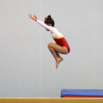 a child is doing a tuck jump which is one of the important expertise for aerobics