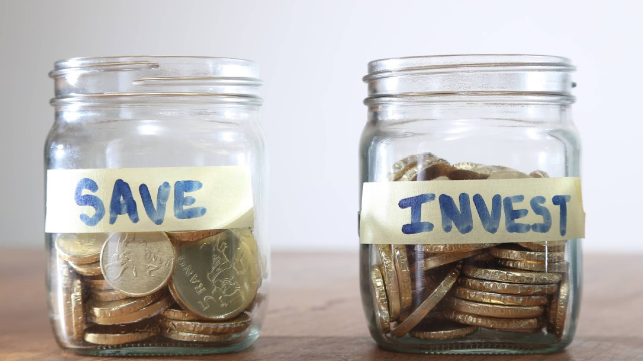 Two jars filled with coins with labels save and invest