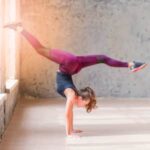 a young women doing handstand with splits