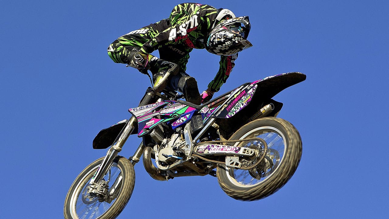 a rider is performing aerial stunts in freestyle motocross racing