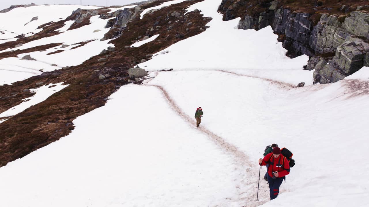 tourist walk across snowy mountains