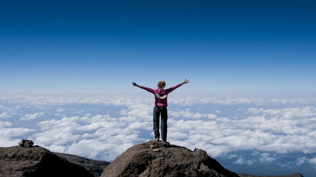 A girl standing on a rock fearlessly, it is the best hiking trails 