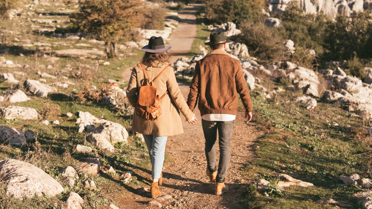 A picture of a man and a women walking together exploring a vibrant new city as they embrace their nomadic lifestyle.