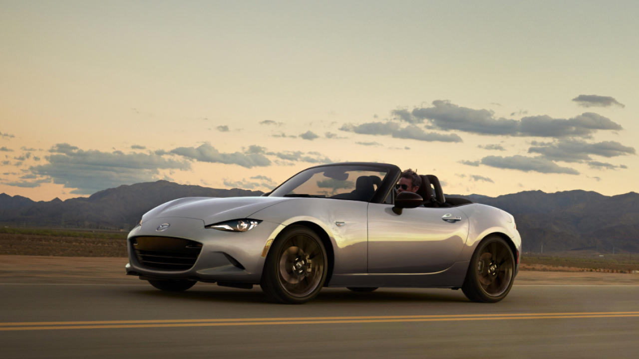 A man driving Mazda MX-5 on a road