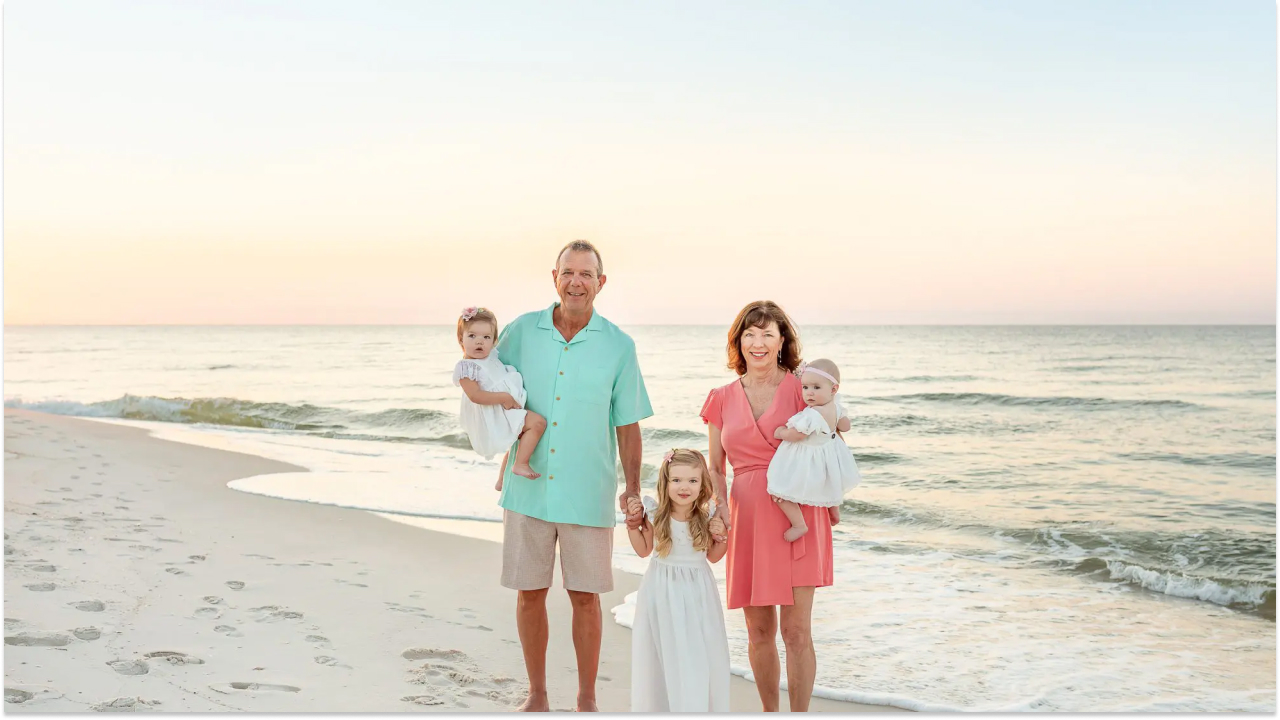 A family is posing for a picture at the beachside