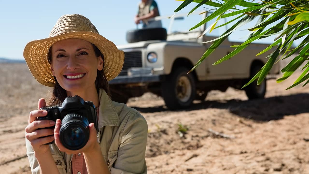 woman holding a camera and smiling