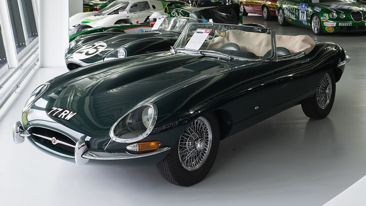 Jaguar E-Type displayed in a showroom along with other cars