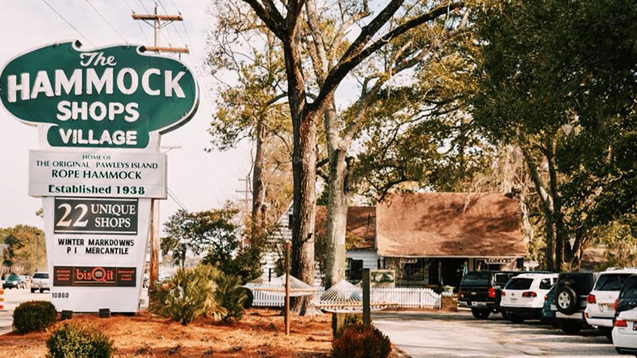 The banner of the hammock shops village, and there are many cars parked in that area.