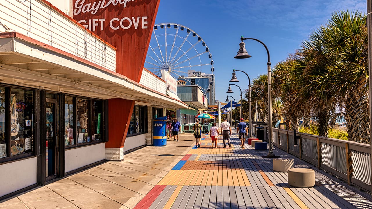 A beautiful sunny day at the Myrtle Beach Boardwalk where a family is walking