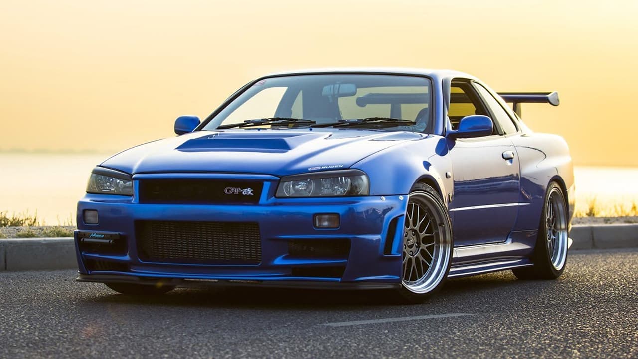 A blue Nissan Skyline GT-R is parked on the side of the road