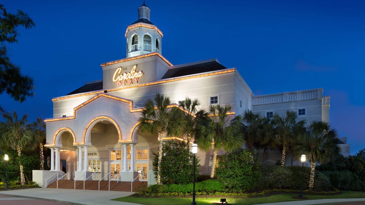 The outside view of a beautiful white building of The Carolina Opry 