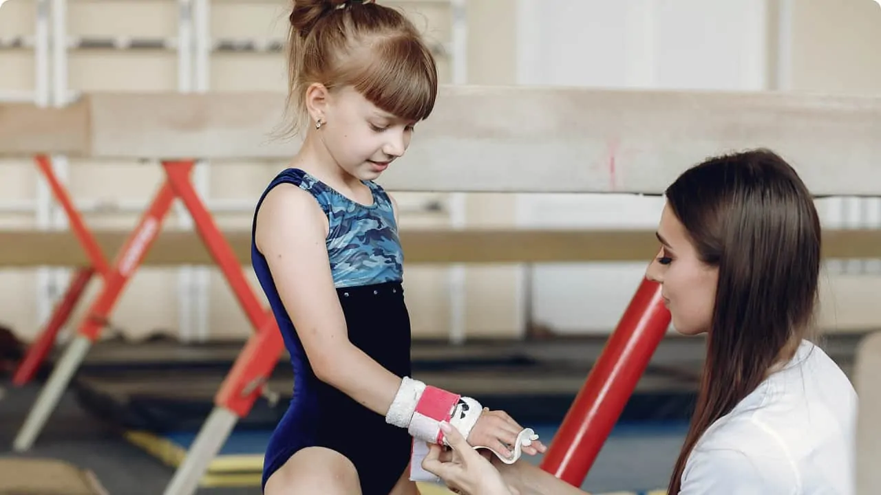 coach with little gymnast performing gymnastic